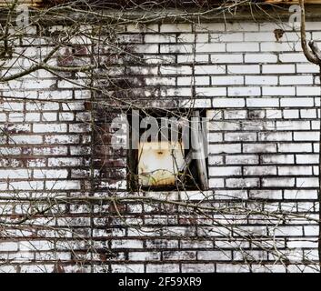 Zerbrochene und verlassene Backsteinlagergebäude mit Fenstern und Tür Stockfoto