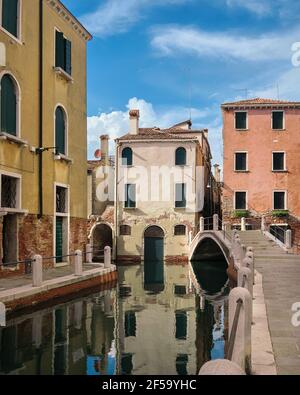 Romantische Kanäle und Wasserstraßen von Venedig. Traditionelle venezianische Brücke und alte bunte Gebäude mit Spiegelungen im Meerwasser. Dorsoduro Nachbarschaft Stockfoto