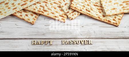 Konzept des jüdischen Feiertags Pesach. Passahfest. Traditionelle Matzah auf weißem Holzhintergrund. Matzobrot. Bannerformat. Stockfoto