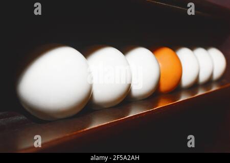 Weiße und eine orange Billardkugeln auf einem Regal Nahaufnahme, weicher Fokus. Stockfoto
