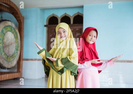 Zwei Kind Mädchen asiatische Muslim lächelnd zeigt etwas Stockfoto
