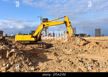 Bagger während der Aushubarbeiten auf der Baustelle. Bagger auf Earthworks. Maschinen für schwere Baumaschinen in Aktion. Big Digger Graben das Foun Stockfoto