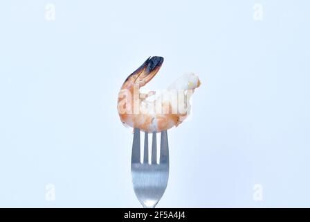 Gegrillte Flussgarnelen stechen durch silberne Gabel auf weißem Hintergrund Stockfoto