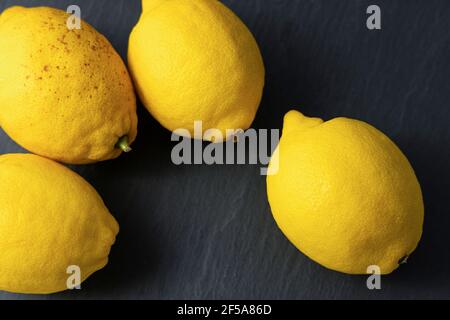 Frische Zitronenfrüchte auf dunklem Schieferhintergrund Stockfoto