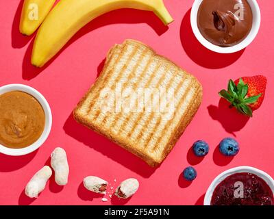 Set von getoasteten süßen Sandwich mit Zutaten auf rosa Hintergrund, Draufsicht, harte Schatten Stockfoto