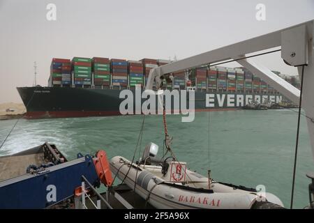 (210325) -- KAIRO, 25. März 2021 (Xinhua) -- EIN Rettungsschiff arbeitet am Standort eines Containerschiffes, das am 25. März 2021 auf dem Suezkanal in Ägypten gefangen war. Die Navigation im Suez-Kanal wurde vorübergehend ausgesetzt, bis die Wiederschwimmarbeiten auf einem Schiff in einem neuen Kurs geerdet ist beendet, sagte Osama Rabie, Vorsitzender der Suez-Kanal-Behörde (SCA) am Donnerstag. Die 224.000-Tonnen je gegeben, ein Panama-Flags-Containerschiff, wurde am frühen Dienstag in der neuen Passage geerdet, nachdem die Fähigkeit, unter starken Winden und einem Staubsturm zu steuern verloren, sagte der SCA in einer Erklärung am Mittwoch. (Suez Canal Auth Stockfoto