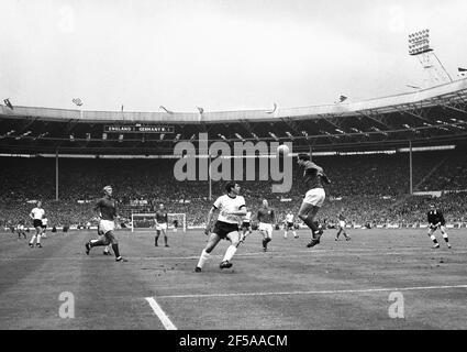 England gegen Westdeutschland WM-Finale 1966, Wembley-Stadion 20th Minuten der ersten Halbzeit. Ray Wilson von England führt den Ball zu Captain Bobby Moore vorbei an Lothar Emmerich von Westdeutschland Foto von Tony Henshaw Archiv Stockfoto