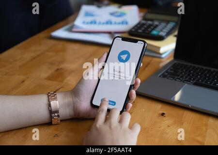 CHIANG MAI, THAILAND, MAR 19, 2021 : Frau Hand hält iPhone X mit Social-Networking-Service Telegram auf dem Bildschirm. IPhone 10 wurde erstellt und Stockfoto