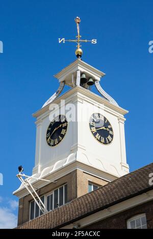 Uhr und Wetterfahne auf dem Clocktower Building des Old Naval Store House in Chatham Historic Dockyard, Kent, England, UK, an einem sonnigen Tag mit blauem Himmel. (121) Stockfoto