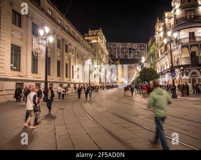 Die Menschen gehen nachts im Winter in den Straßen von Sevilla Spanien Stockfoto