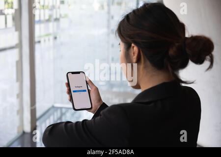 CHIANG MAI, THAILAND - MÄR 01, 2021: Eine Frau Hand hält iphone mit Login-Bildschirm der instagram-Anwendung. Instagram ist die größte und beliebteste Stockfoto