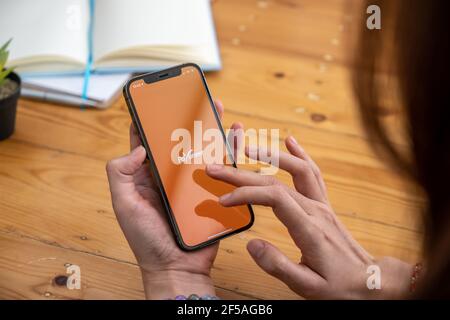 CHIANG MAI, THAILAND - Mar 08, 2021 Frau mit Payoneer auf dem iPhone mit Tablet auf Hintergrund. Payoneer ist ein weltweites Online-Zahlungssystem Stockfoto