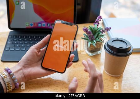 CHIANG MAI, THAILAND - Mar 08, 2021 Frau mit Payoneer auf dem iPhone mit Tablet auf Hintergrund. Payoneer ist ein weltweites Online-Zahlungssystem Stockfoto