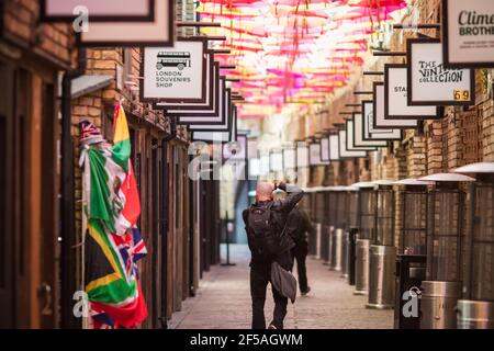 London, Großbritannien - 26. Februar 2021 - EIN Mann, der Fotos macht, während alle Geschäfte am Camden Market während der nationalen Sperre geschlossen sind Stockfoto