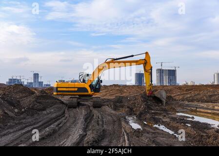 Bagger während der Aushubarbeiten auf der Baustelle. Bagger auf Earthworks. Maschinen für schwere Baumaschinen in Aktion. Big Digger Graben das Foun Stockfoto