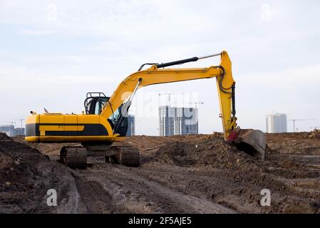 Bagger während der Aushubarbeiten auf der Baustelle. Bagger auf der Straße arbeiten. Maschinen für schwere Baumaschinen für Erdarbeiten. Bagger an der Brückenkonstruktion Stockfoto