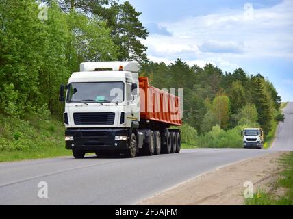 LKW mit Kipper Sattelauflieger transportierte Sand aus dem Steinbruch auf der Fahrt entlang der Autobahn. Moderne Dump Semi-Trailer Heckkipper Lkw-Anhänger Stockfoto