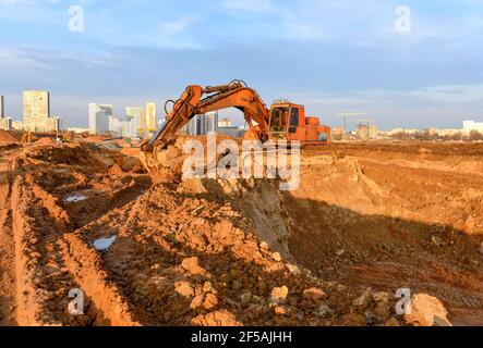 Bagger während der Aushubarbeiten auf der Baustelle. Bagger auf Earthworks. Maschinen für schwere Baumaschinen in Aktion. Big Digger Graben das Foun Stockfoto