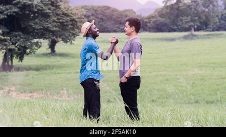Konzept der besten Freunde, afrikanischen Mann und asiatischen Mann Handshake mit Lächeln und glücklich Stockfoto