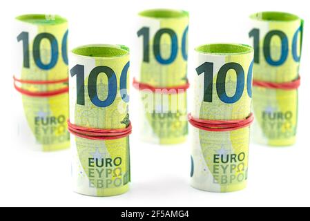Makroaufnahme der Europäischen Union 100 EURO Banknote, ein paar Scheine in einem Gummiband zusammengerollt, isoliert auf weißem Hintergrund. Stockfoto