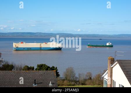 Zwei Schiffe, die in der Severn-Mündung vor Portishead, Großbritannien, vorbeifahren, während die Mündung die Flut erreicht. Die Schiffe nutzen das Royal Portbury Dock Stockfoto