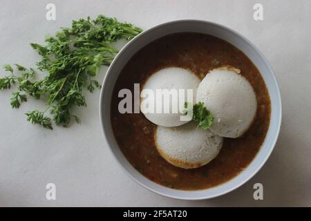 Idli Sambhar ein indisches Essen in der Regel in Südindien hergestellt, aber mochte und zubereitet fast in allen Teilen von Indien. Schön plattiert. Aufnahme auf weißem Hintergrund Stockfoto