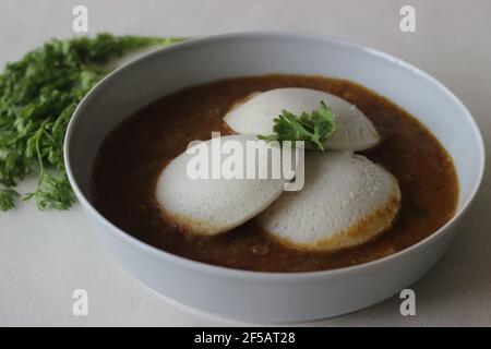 Idli Sambhar ein indisches Essen in der Regel in Südindien hergestellt, aber mochte und zubereitet fast in allen Teilen von Indien. Schön plattiert. Aufnahme auf weißem Hintergrund Stockfoto