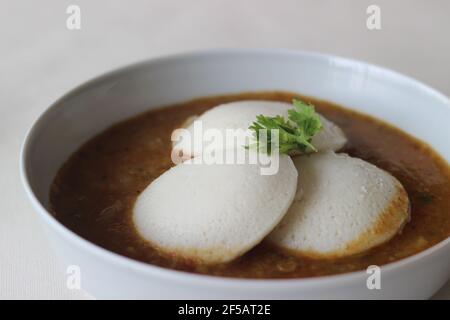 Idli Sambhar ein indisches Essen in der Regel in Südindien hergestellt, aber mochte und zubereitet fast in allen Teilen von Indien. Schön plattiert. Aufnahme auf weißem Hintergrund Stockfoto