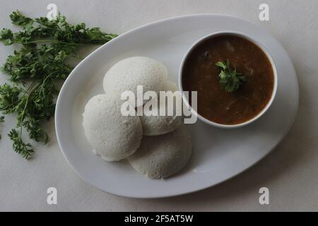Idli Sambhar ein indisches Essen in der Regel in Südindien hergestellt, aber mochte und zubereitet fast in allen Teilen von Indien. Schön plattiert. Aufnahme auf weißem Hintergrund Stockfoto