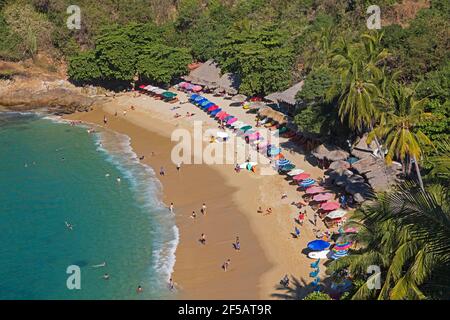 Touristen Sonnen und Schwimmen in Playa Carrizalillo, geschützte Bucht mit Sandstrand in der Nähe von Puerto Escondido, San Pedro Mixtepec, Oaxaca, Mexiko Stockfoto