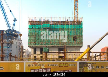 Shanghai, China, Asien - traditionelle chinesische Gerüste, die ein Gebäude im Bau umwickeln. Stockfoto