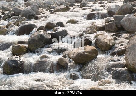 Das Wasser, das in den schnellen Strömungen fließt, trifft die Felsen Und zieht mit seinem Sound die Aufmerksamkeit aller auf sich Stockfoto