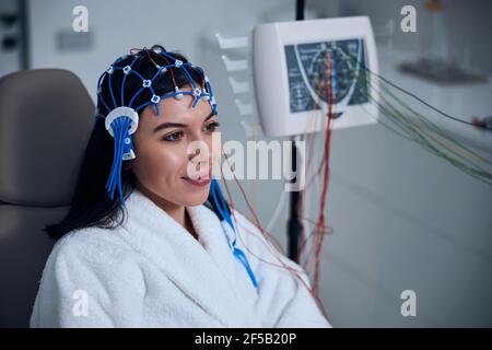 Erfreulicher weiblicher Patient, der einen EEG-Test durchläuft Stockfoto