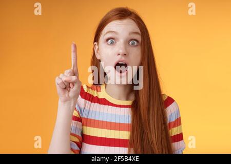 Idee schnell zuhören. Aufgeregt junge emotionale rothaarige weibliche Mitarbeiterin Anheben Zeigefinger eureka Geste öffnen Mund weite Augen schockiert begeistert Stockfoto