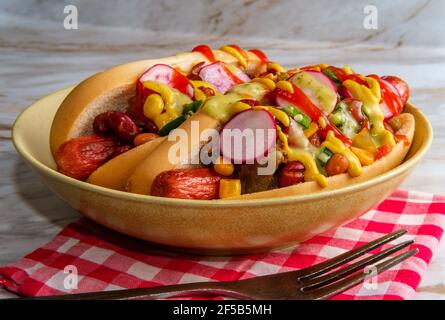 Ausgefallene Chili-Hunde mit Radieschen Senf Ketchup und grün gekrönt Soße auf glutenfreien Brötchen Stockfoto