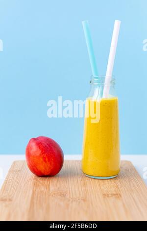Smoothie oder Cocktail aus Nektarine, Mandelmilch und Kurkuma in einem Glas. Stockfoto