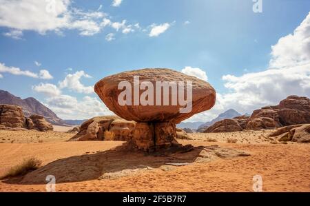 Pilzförmiger Felsen in der Wüste Wadi Rum, helle Sonne scheint auf dem Hintergrund der Berge Stockfoto