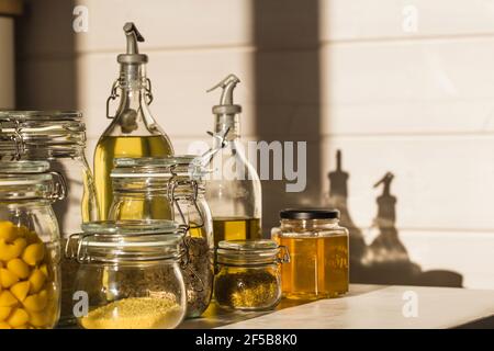 Auswahl an ungekochten Körnern, Getreide und Pasta in Gläsern auf Holztisch. Gesundes Kochen, sauberes Essen, Null-Abfall-Konzept. Stockfoto