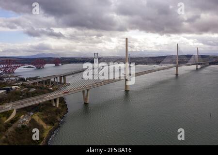 North Queensferry, Schottland, Großbritannien. März 2021, 25th. IM BILD: Bewölkt, windig mit Schauern. Drohnenfotografie Luftaufnahme von oben Blick nach Süden über den Firth of Forth mit den drei Brücken; Queensferry Crossing (Hauptbild), eine Brücke, die die Autobahn M90 trägt, mit der Forth Road Bridge dahinter und die Forth Rail Bridge links. BILD: Kredit: Colin Fisher/Alamy Live News Stockfoto