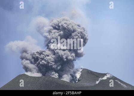 Mt Tavurvur aktiver Vulkan. Rabaul, Papua-Neuguinea. Es gibt einen kräftigen Boom und dann steigen die Asche- und Rauchwolken aus der Caldera. Aufgenommen mit einem Stockfoto