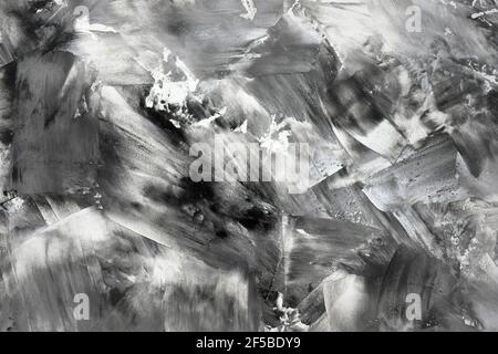 Abstract black-white background. Smears of white and black paint on the canvas, top view. Black and white contrasting paint texture Stockfoto