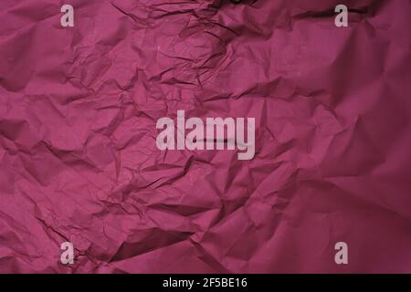 Dunkelroter Hintergrund von der Verpackung zerknittertes Papier. Burgundy Blatt zerknittertes Papier Draufsicht. Die Falten auf der Oberfläche schließen. Stockfoto