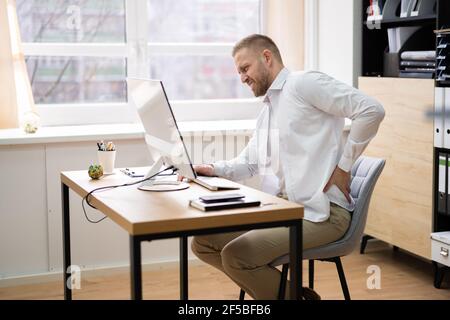 Schlechte Körperhaltung, Die Am Schreibtisch Sitzt Und Den Computer Benutzt Stockfoto