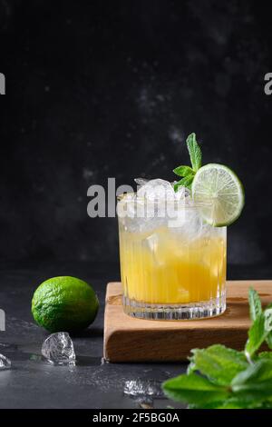 Mai Tai Klassischer Rum-Cocktail. Tropische Limonade mit Limettengarnitur Minze auf Schwarz. Vertikales Format. Stockfoto