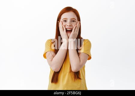 Überrascht Ingwer Mädchen mit Sommersprossen Auschecken etwas genial, starren mit Erstaunen und Freude an Überraschung Geschenk, stehen glücklich gegen weiß Stockfoto