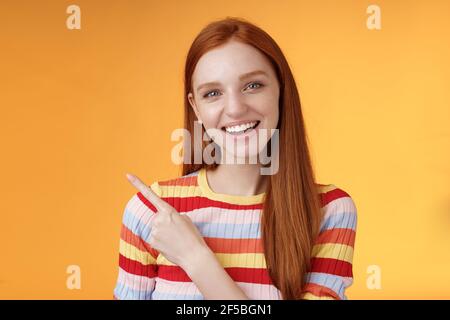 Freundliche ausgehende gut aussehende Ingwer Mädchen Universität Student diskutieren Vorlesung Klassenkamerad Lächelnd lachend, zeigend in der linken oberen Ecke gefragt Stockfoto