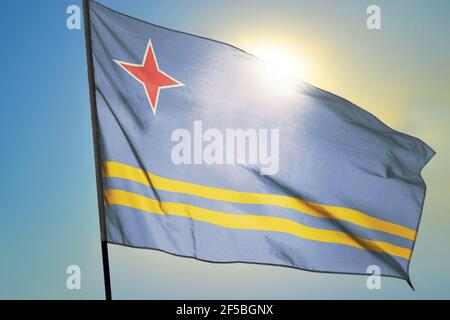 Aruba Flagge winkt im Wind vor der Sonne Stockfoto