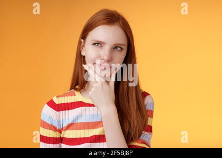 Hmm interessant. Verdächtig zweifelhaft attraktiv europäischen Rotschopf weiblich erwägen Wahl schauen zögerlich nachdenklich Touch Kinn schmunzend tricky Blick Stockfoto