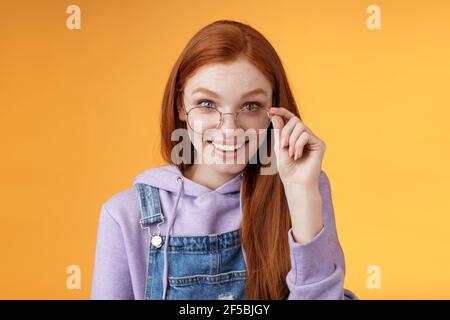 Charming albern bescheiden jungen Rotschopf weibliche Geek Spiel Liebhaber Diskus Die letzten Gaming-Trends lächeln fröhlich amüsiert Touch-Brille grinst neugierig Empfangen Stockfoto