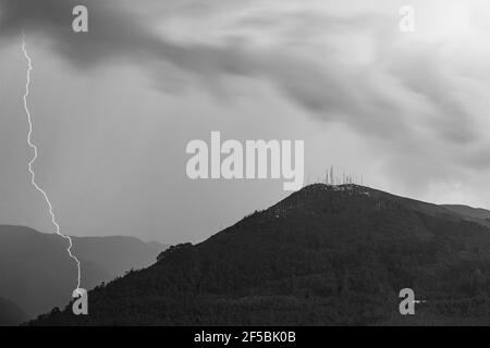 Schwarz-Weiß-Fotografie des Vulkans Pichincha mit Gewitterblitz, Quito, Ecuador. Konzentrieren Sie sich auf den Berggipfel. Stockfoto